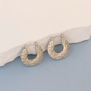 Detail view of oval C-shape earrings with vintage rock texture finish on stone