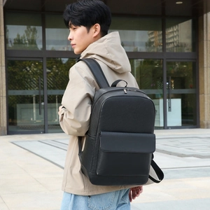 Minimalist black leather business backpack for commuting with padded straps on a person