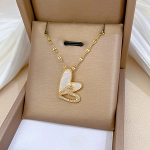Detail of double heart pendant with pearl shell and crystals on gold chain