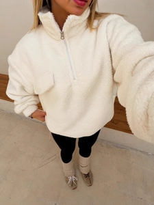 White fleece half-zip pullover with chest pocket design in a cozy minimalist interior