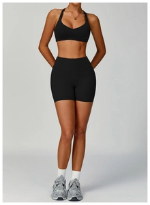 Close-up of black high-waisted yoga shorts and sports bra featuring matte elastic fabric
