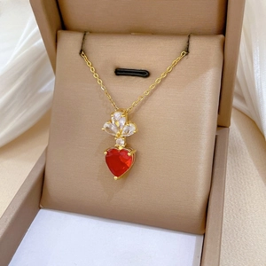 Close-up of red heart pendant with white crystals in a premium gift box