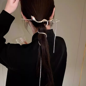 Detailed view of silver snake hair pin with sparkling rhinestone tassel in a ponytail hair style