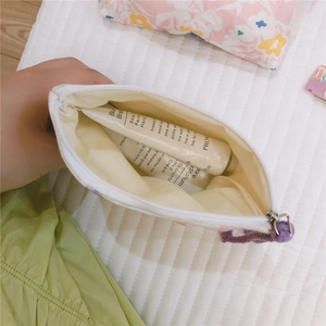 Macro detail of floral cotton pouch showing inner lining and capacity with metal zipper