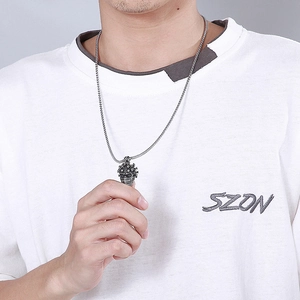 Gros plan d'un pendentif casque crâne en acier inoxydable punk avec chaîne maille box