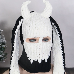 Detail of knitted balaclava with white devil horns and long ears for winter party