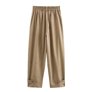 Detail of khaki wide-leg trousers featuring elastic high waist and buttoned cuffs