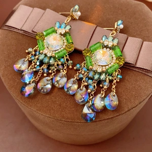 Detail of bohemian drop earrings with crystals and pearls on brown velvet jewelry box
