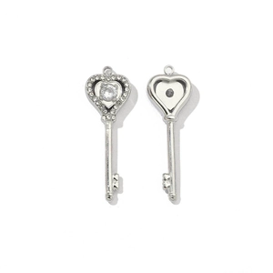 Detailed macro view of heart-shaped silver key pendants with sparkling crystal inlay