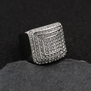 Silver 316 stainless steel four-row iced out hip hop ring on a textured rock
