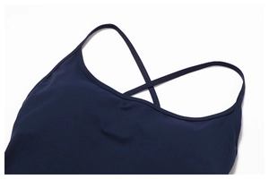 Detail of navy blue moisture-wicking bodysuit showing cross back straps and knit texture