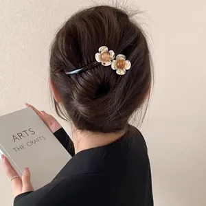 Gros plan sur la pince à cheveux vintage française avec fleurs crème et perles ambrées