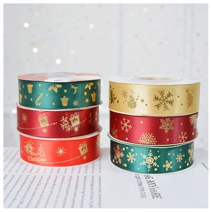 Detail of 2.5cm satin Christmas ribbons with gold foil Merry Christmas prints and snowflakes