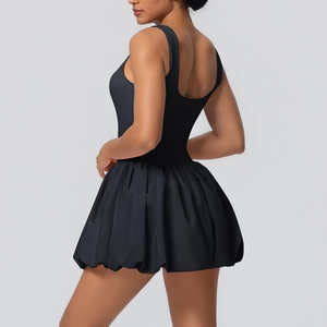 Detail view of the pleated skirt hem on a black sleeveless athletic fitness dress