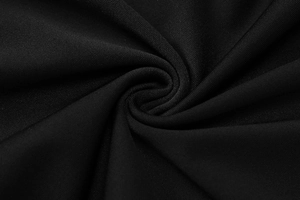 Close-up of high-density black knit fabric showing the fine texture and soft draping