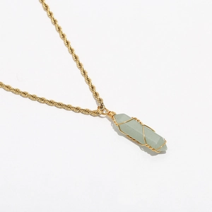 Detail of light green hexagonal crystal pendant with gold wire wrap on rope chain