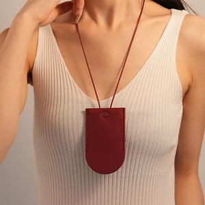 Detail of burgundy leather necklace key holder pouch with premium stitching shown on model