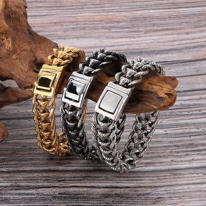 Trois coloris de bracelets chaîne dragon pour hommes présentés sur du bois naturel