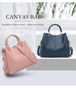 Close-up of pink and blue faux leather handbags with crocodile texture and metal handles