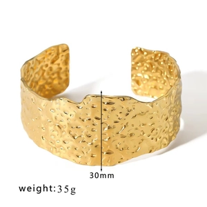 Detail of 30mm wide gold titanium steel cuff bracelet featuring hammered metal texture