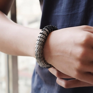 Close-up of vintage dragon scale pattern cast in stainless steel on a men's wrist