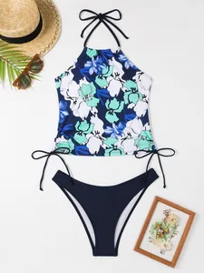 Flat lay of floral halter bikini set with navy bottoms and summer beach accessories