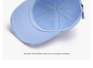Close-up of light blue distressed baseball cap with stitching and metal buckle details