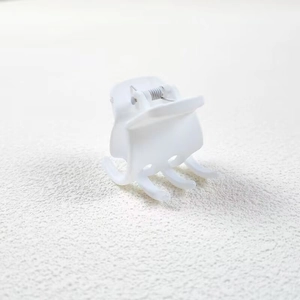 Detail view of a 3.5cm small white square claw clip for half-up hairstyles on white surface