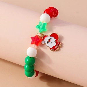 Close-up of beaded Christmas bracelet with red and green stars and Santa Claus charm