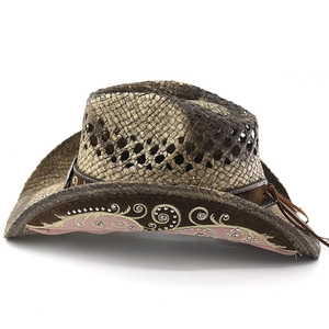 Detail of straw cowboy hat featuring floral embroidery, silver rhinestones, and leather tassels