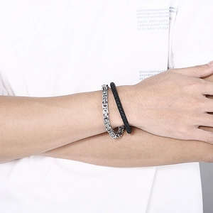Nahaufnahme von Herren-Byzanz-Silberkette und schwarzem geflochtenem Lederarmband
