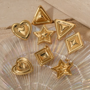 Polished gold geometric earrings set with heart star and triangle shapes on tray