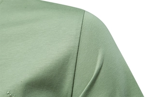 Macro detail of high-quality shoulder stitching and fine fabric texture on olive green T-shirt