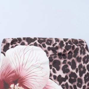 Detailed macro view of leopard print and red orchid pattern on stretch fabric dress