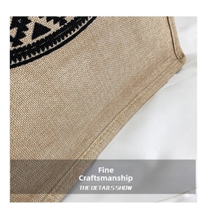 Detail of linen texture and neat stitching with black geometric patterns on a tote bag