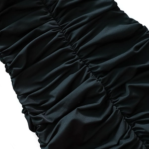 Detail of black ruched fabric texture with elastic shirring on a bodycon midi dress