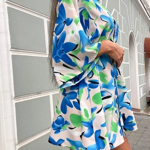 Vue latérale détaillée du haut élégant à fleurs bleu et vert avec encolure en V