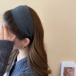 Detail eines dunkelgrauen breiten Strickstirnbands mit weicher Textur und schickem Stil