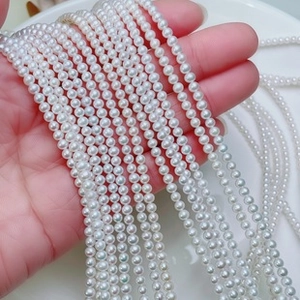 Close-up of small white freshwater pearls with high luster on 925 silver ear wire