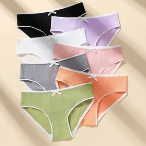 Detail of seven colorful lace panties with ribbed texture and decorative bow
