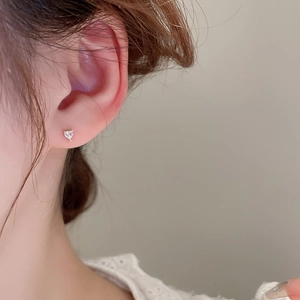 Gros plan d'une puce d'oreille cœur en zircon avec placage en or sur le lobe