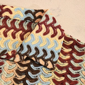 Detailed close-up of multi-color wavy crochet knit fabric with lapel collar detail