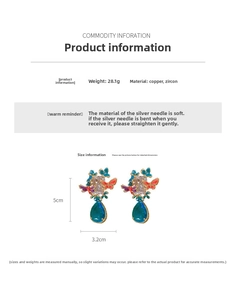 Macro detail of copper earrings with enamel butterflies and blue waterdrop zircon