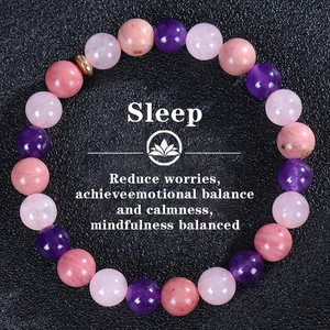 Detailed macro shot of natural amethyst and quartz beads on a black textured surface
