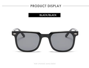 Detail view of black square sunglasses with silver arrow rivets and smoke grey lenses