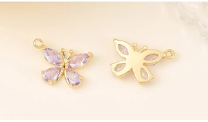 Detailed front and back view of golden butterfly charms with purple zircon crystals