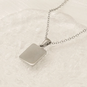Polished silver rectangular stainless steel pendant necklace on transparent bubble background