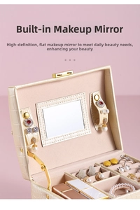 Detail of jewelry box interior with crocodile texture, vanity mirror, and pink velvet lining