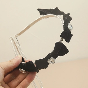 Chic black flocked bow headband with sparkling heart-shaped rhinestones on silver metal