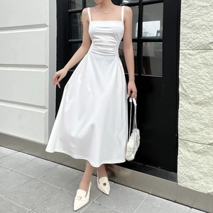 Detail of elegant white midi dress showing side pleated waist design and square neckline
